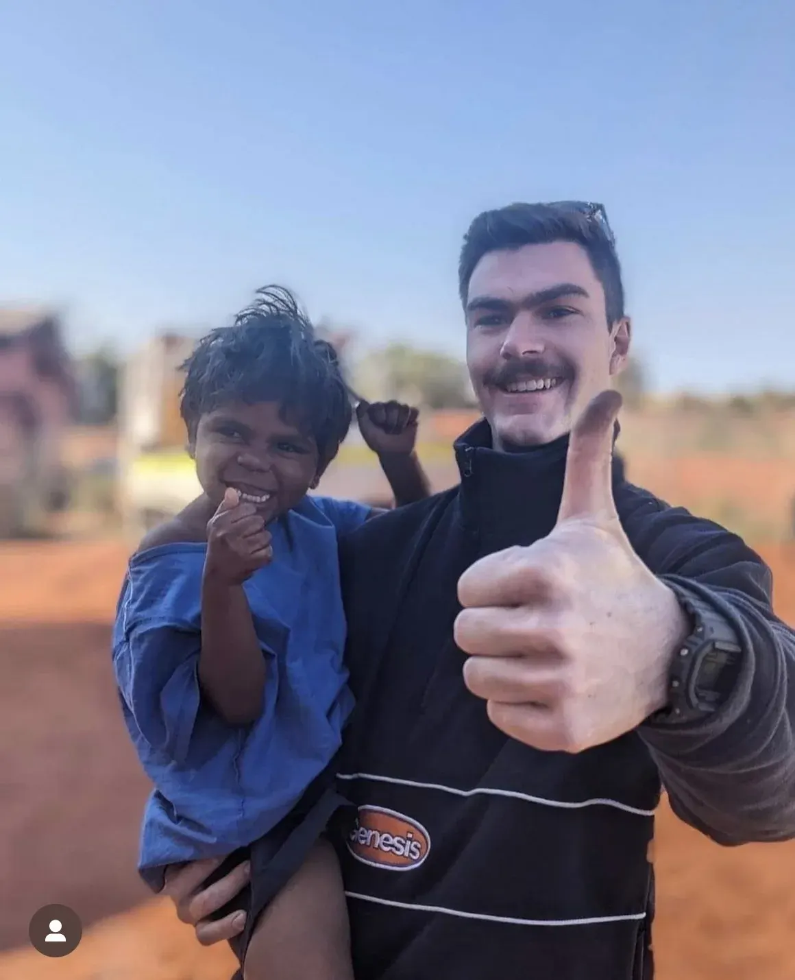 Infinity team member smiling with a young child, giving a thumbs up