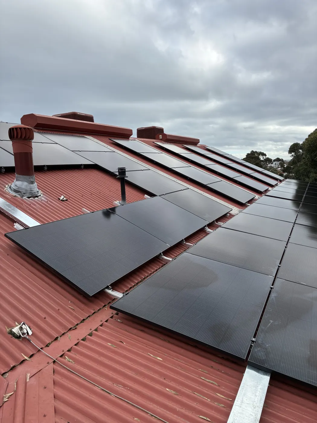 Black solar panels on the red roof at Beaconsfield Primary School