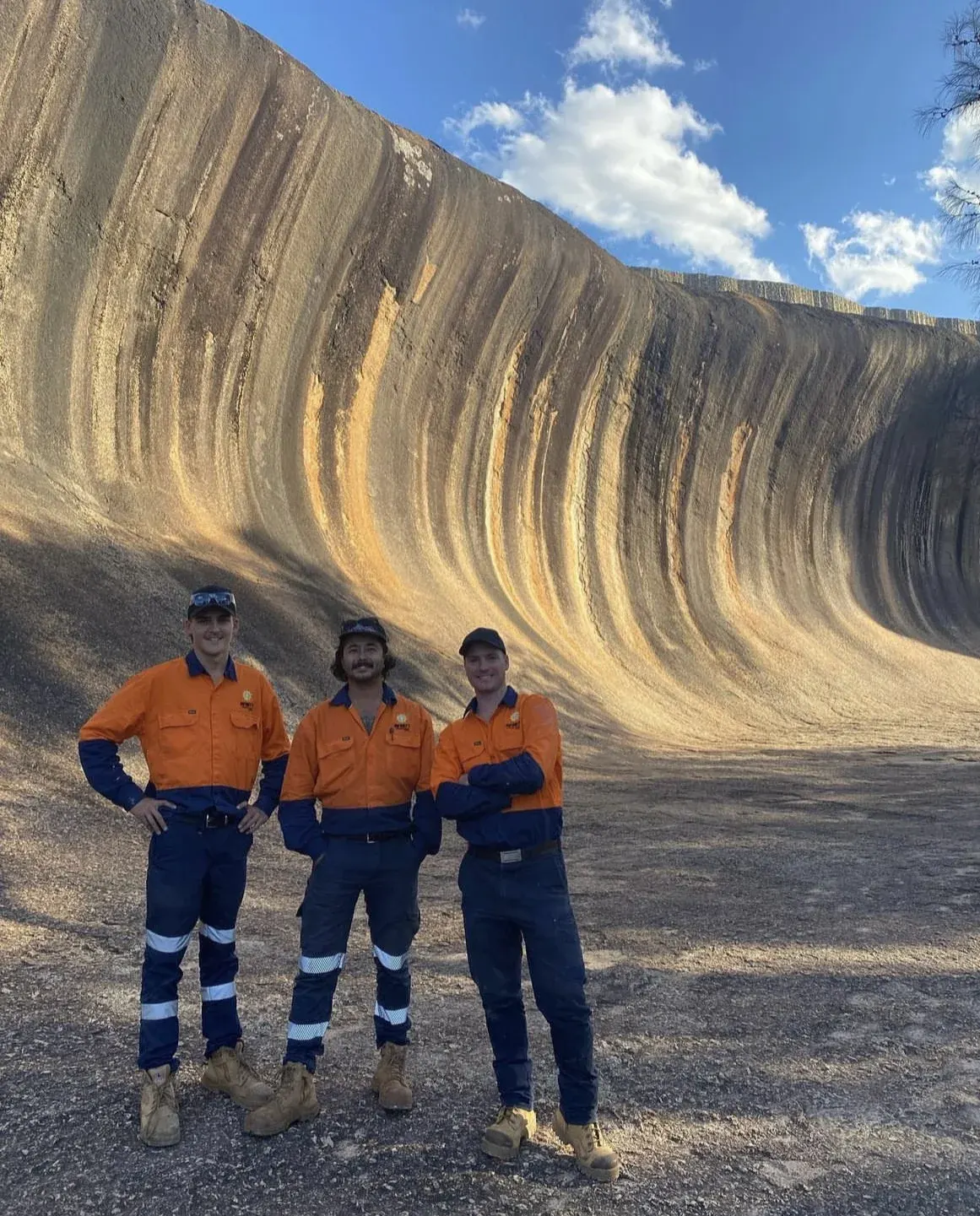 Infinity team members in hi-vis in front of Wave Rock